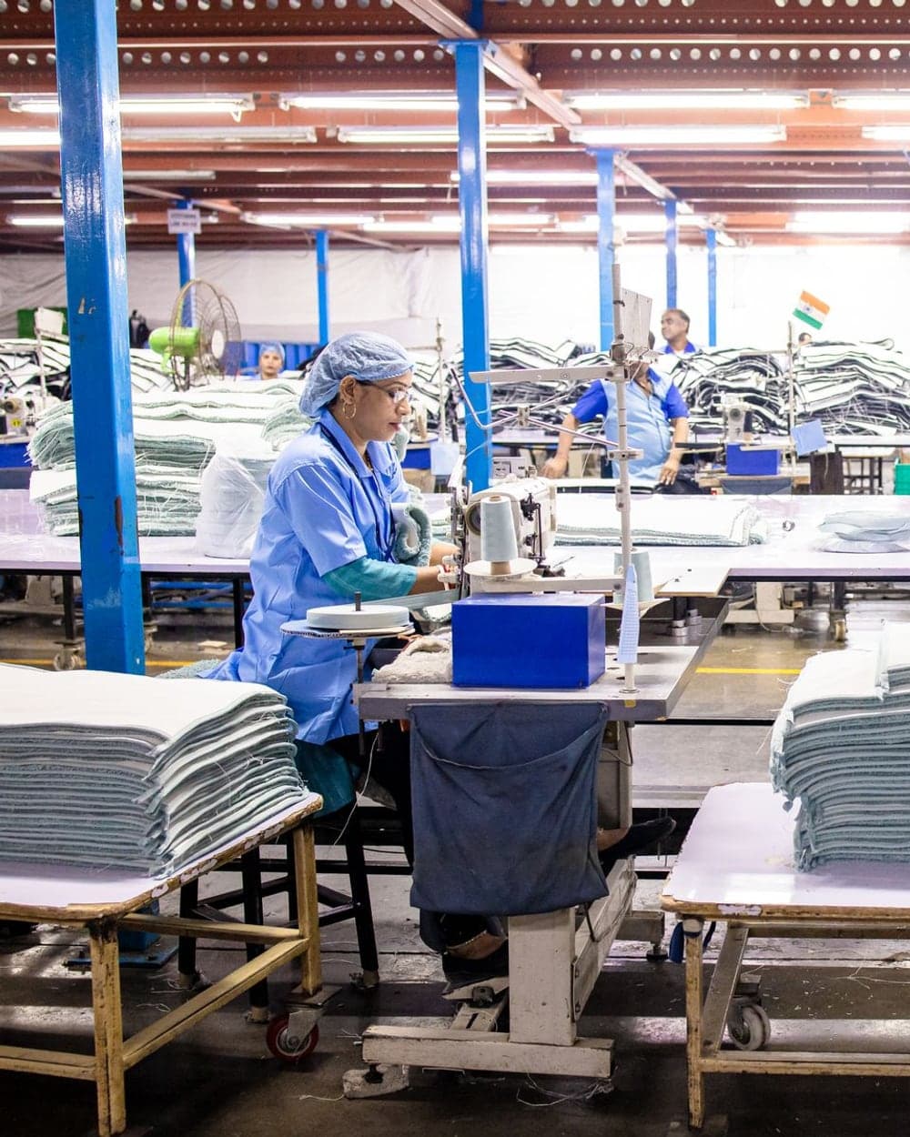 Garment factory workers operating sewing machines on the production floor