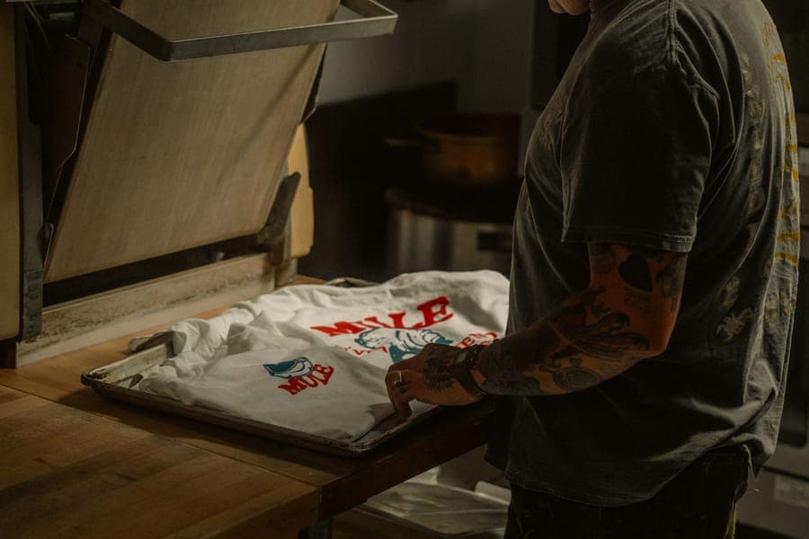 Heat-press applying a DTF transfer to a garment
